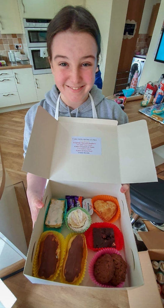 Young girl, MIa Pritchard, with box of home made cakes